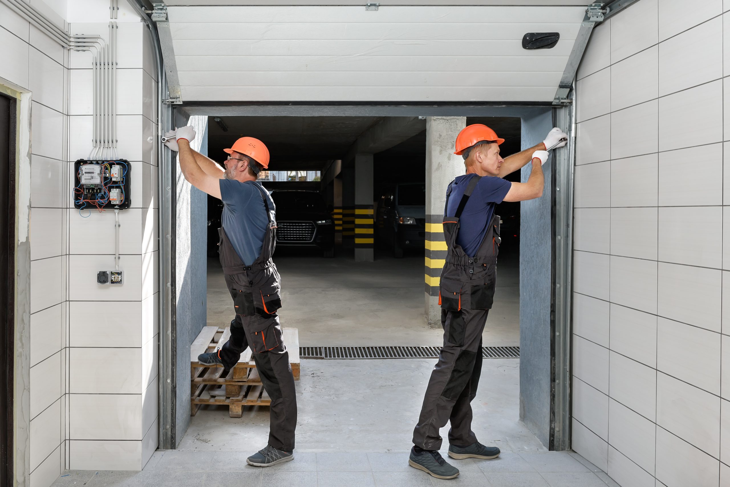 Une réparation de porte de garage à Lyon par deux professionnels.